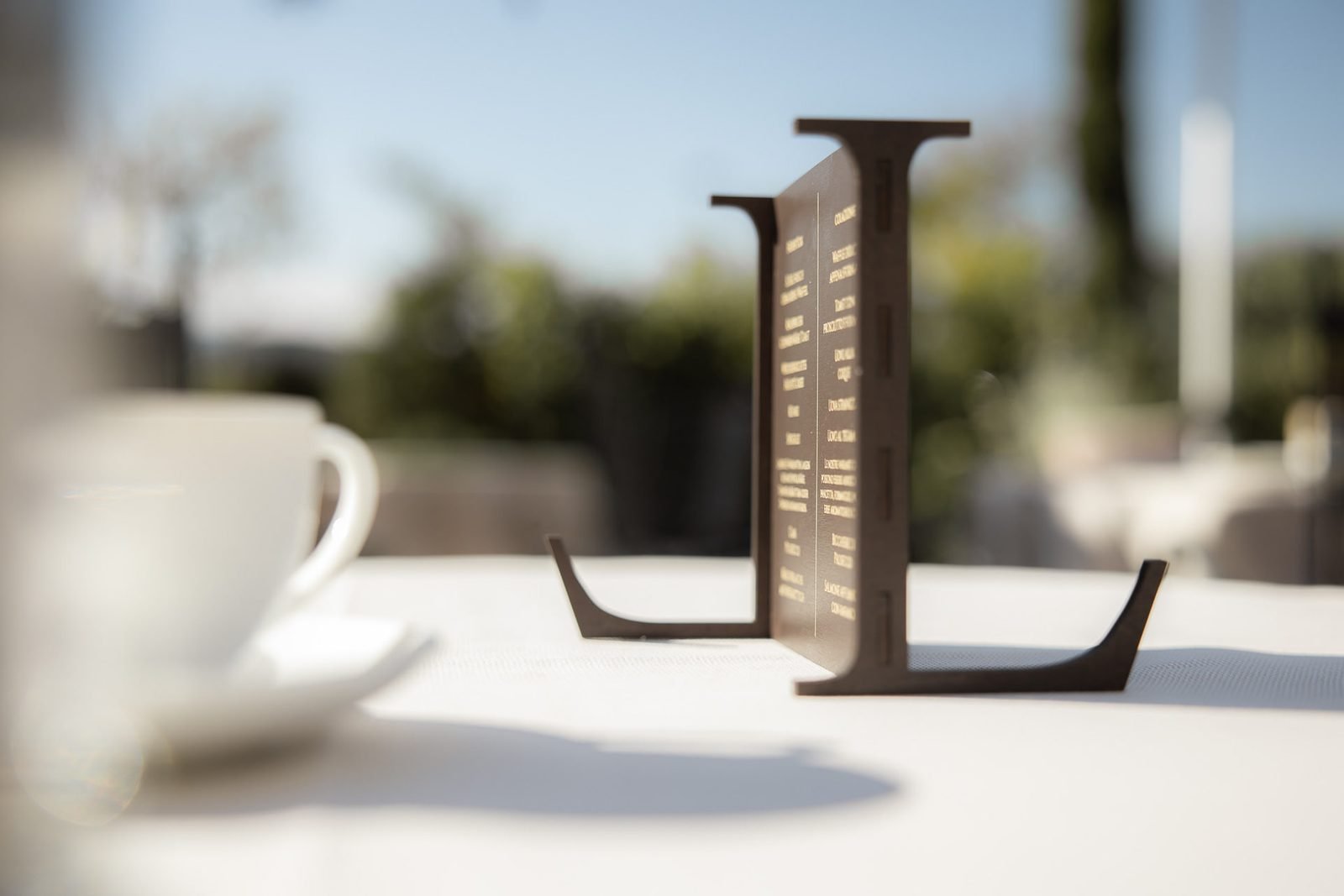 Espressotasse vor dem Schriftzug des Hauses
