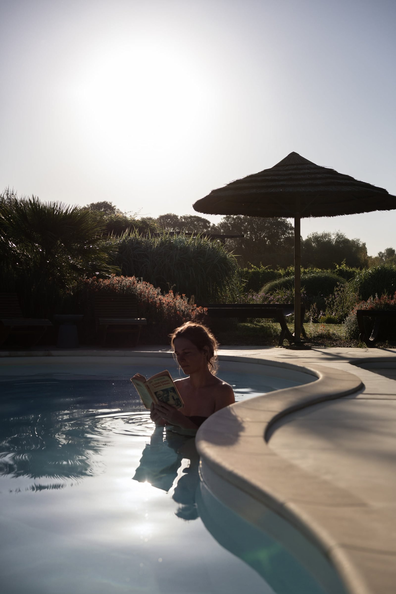 Gast liest entspannt im beleuchteten Pool
